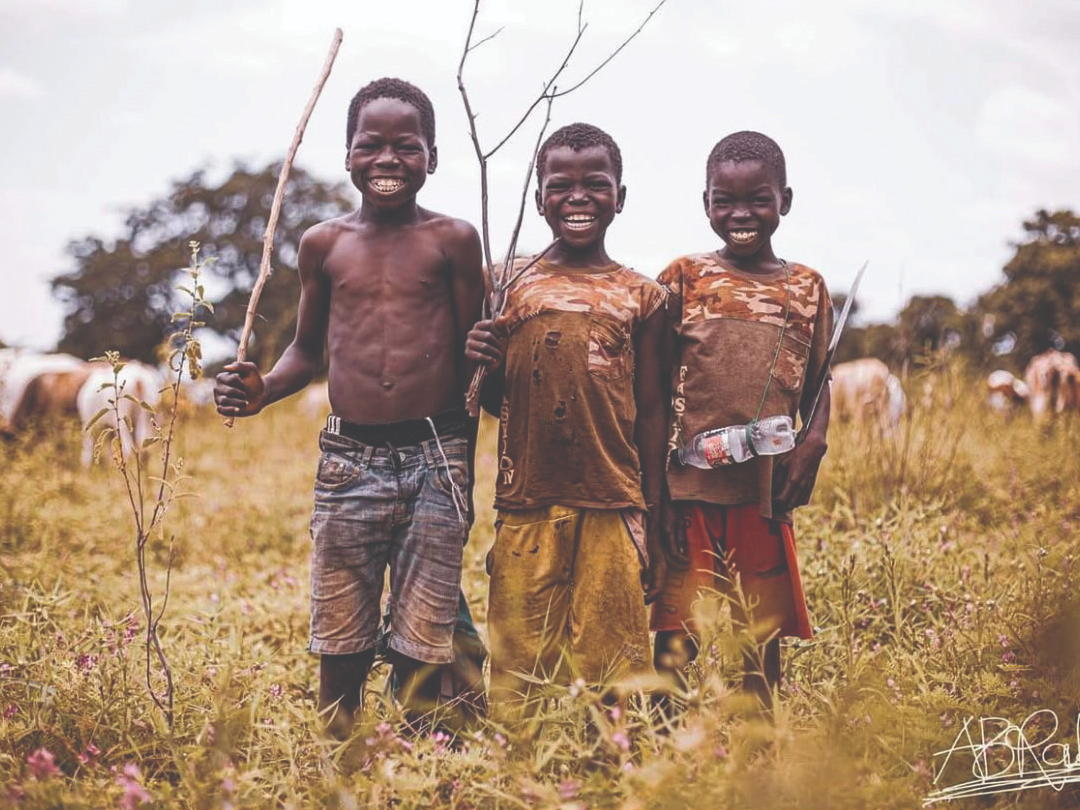Young boys smiling in a rural field in Zimbabwe